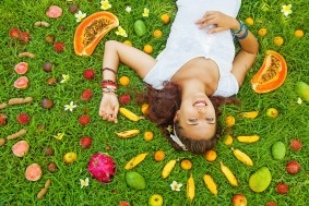 woman lying on a grass with the pattern of colorful fresh exotic